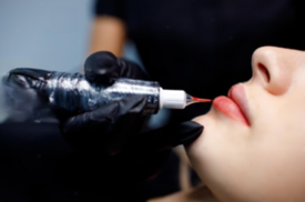 A woman undergoing lip tattooing