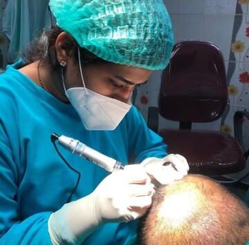 Dr. Sneha Kovi, the best dermatologist in Guntur performing scalp micropigmentation treatment to a patient